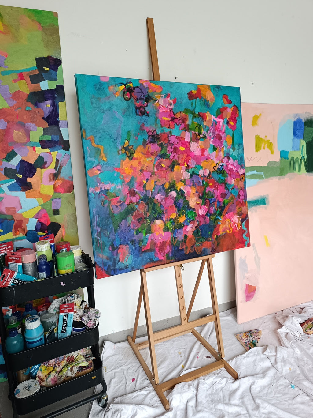 Abstract floral canvas on wooden stand in natural light
