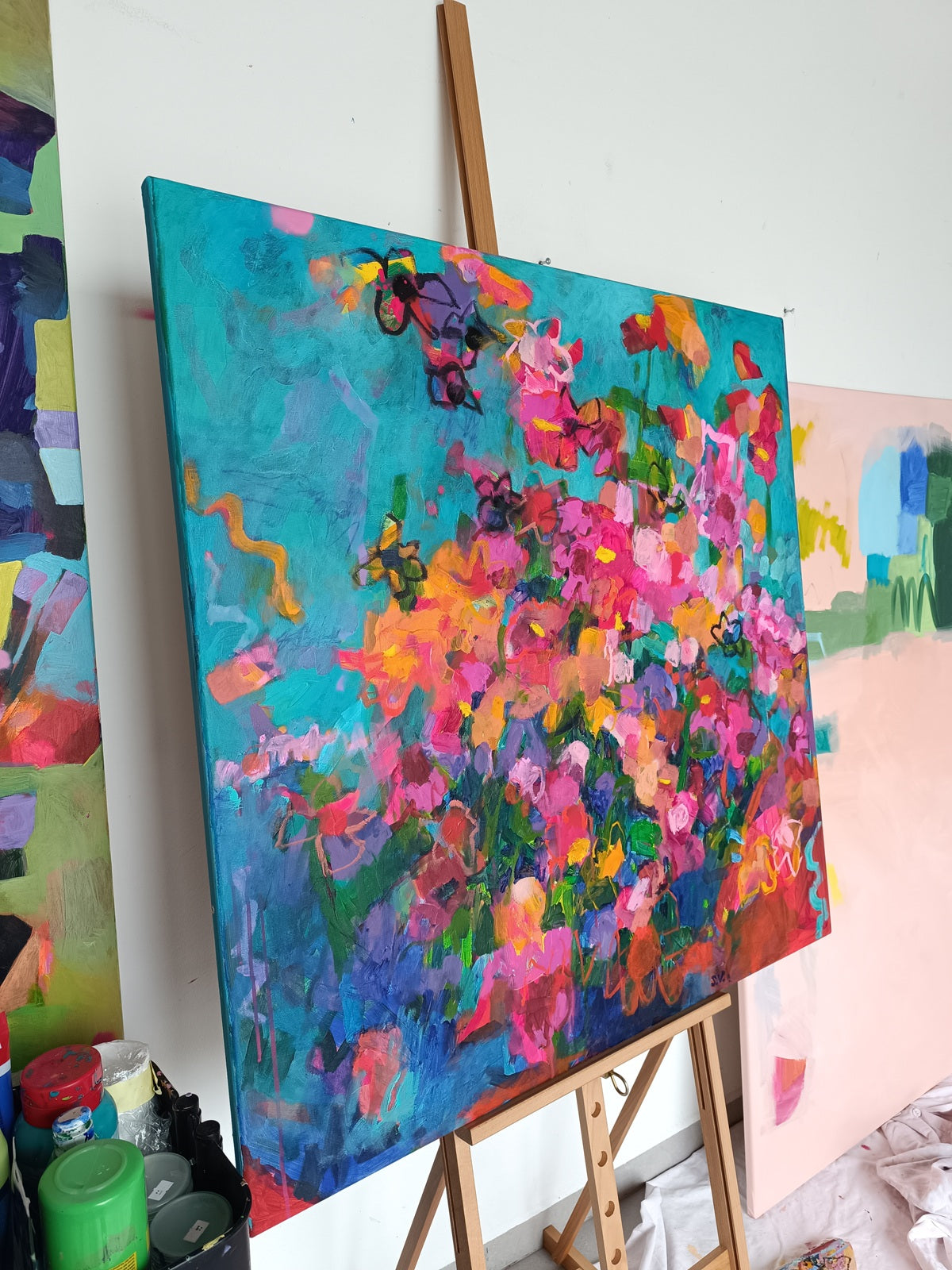 Colorful abstract flower painting presented on studio easel
