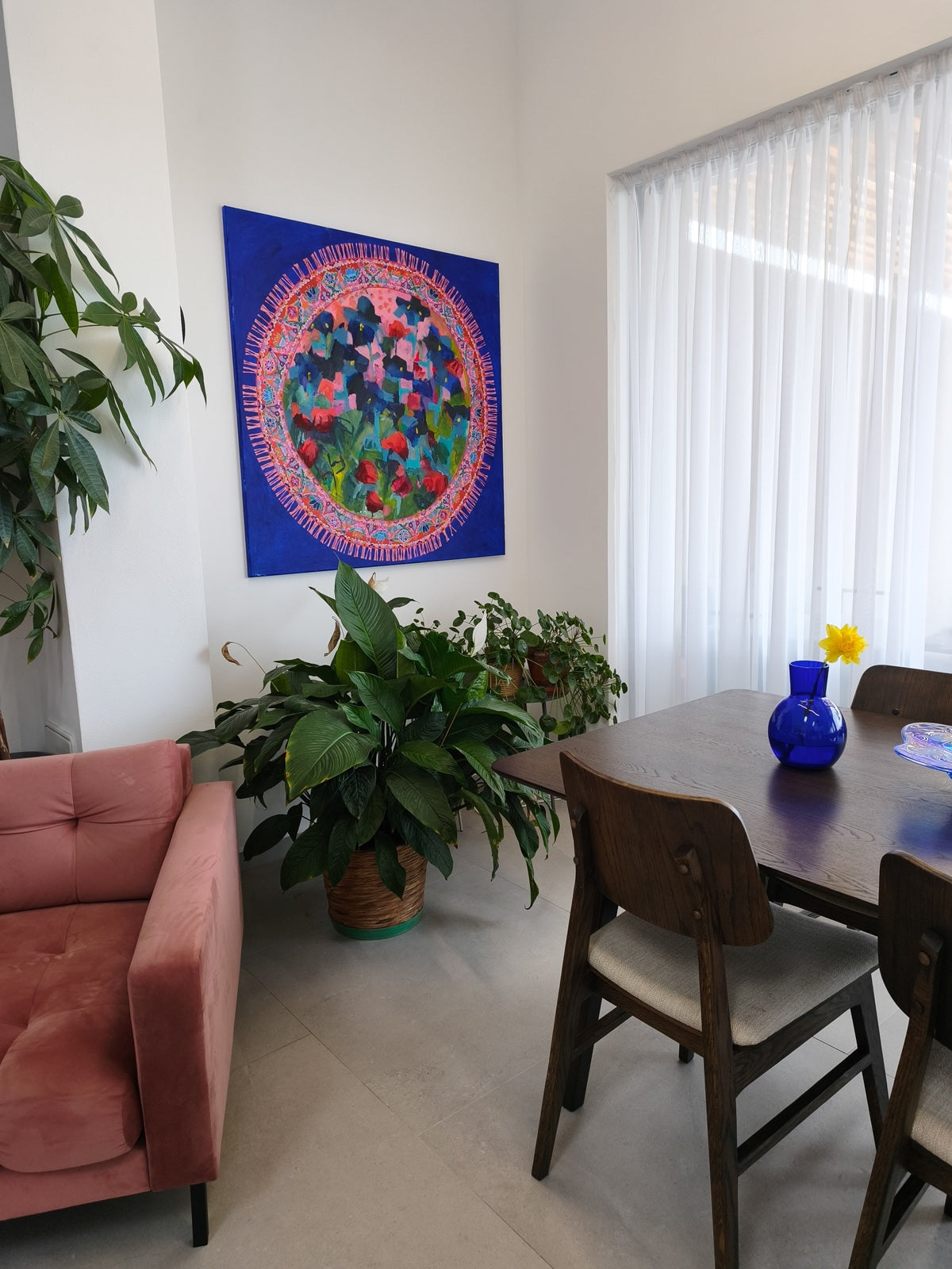 Large abstract floral painting Blooming Rug displayed in modern living room with sofa, table and blue vase