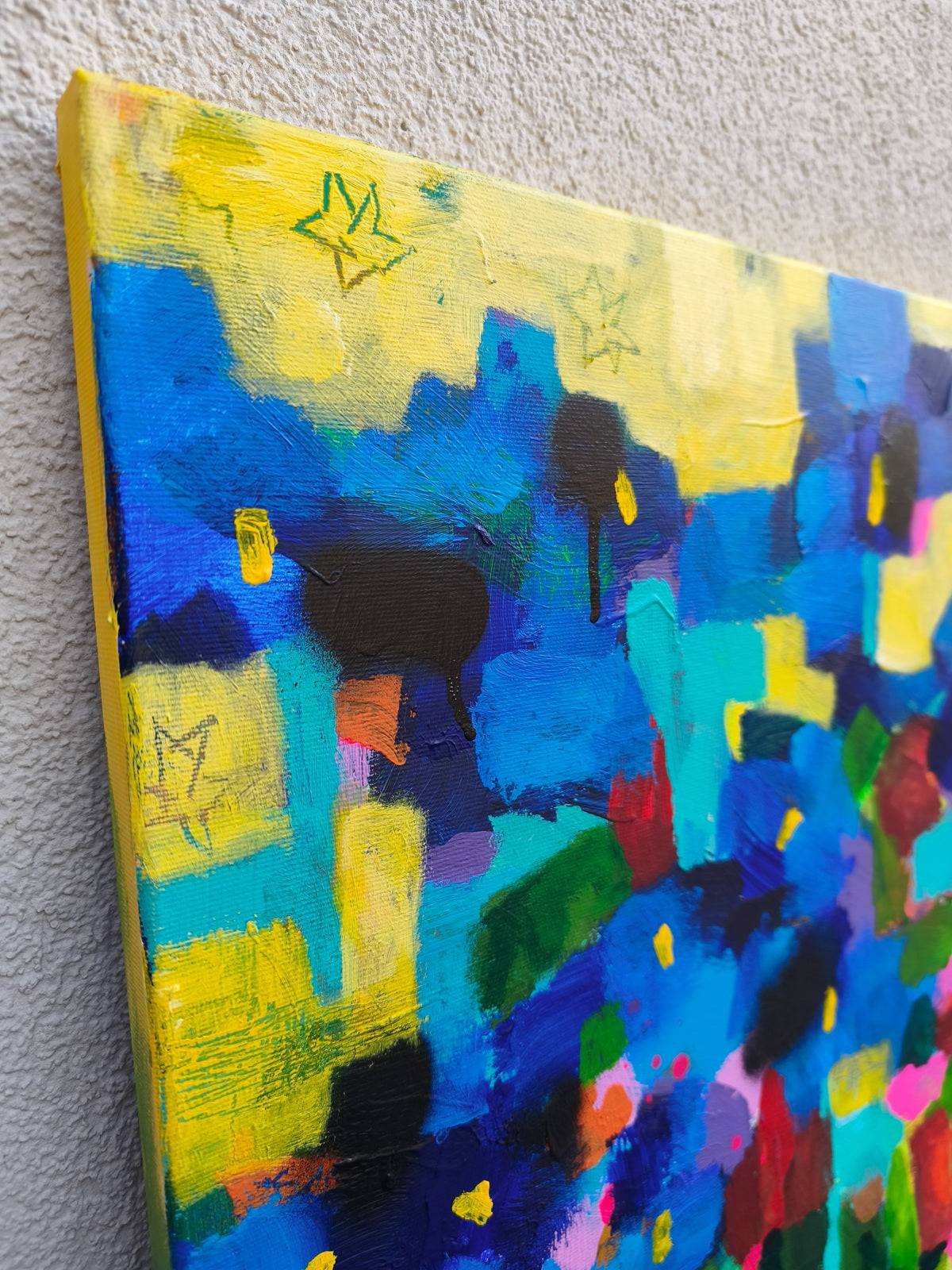 Textured detail of small abstract painting with floral elements, red flowers and star-like details on yellow background